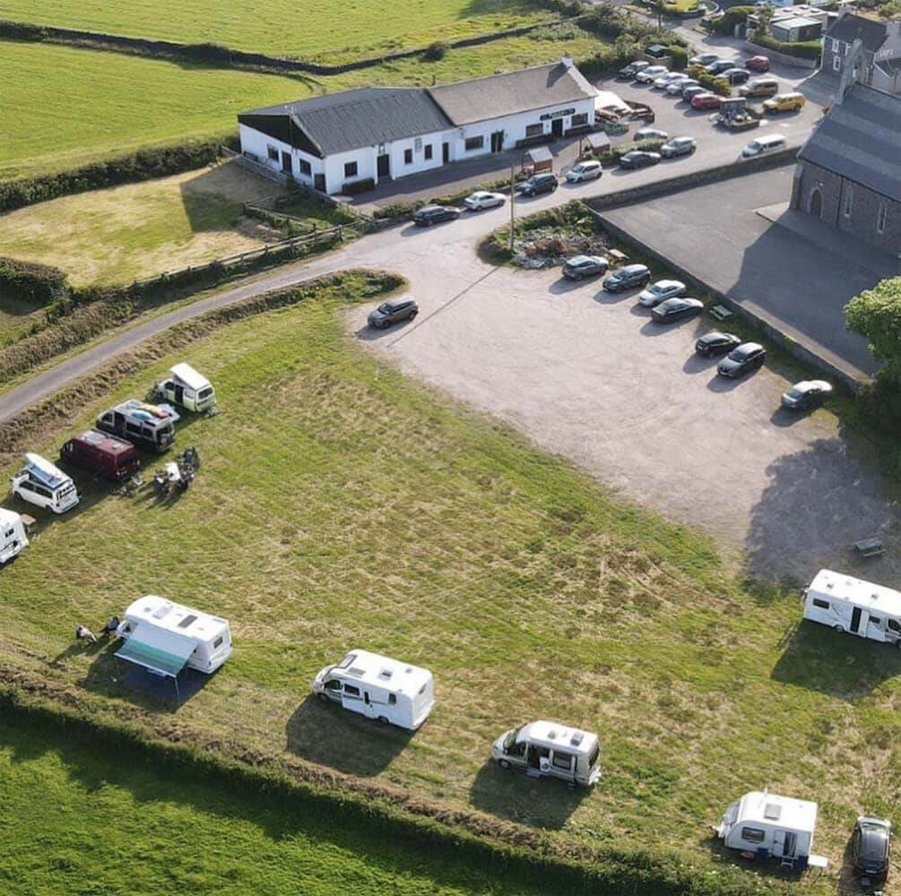 Camping-cars installés sur le terrain en herbe près du pub Páidí Ó Sé.
